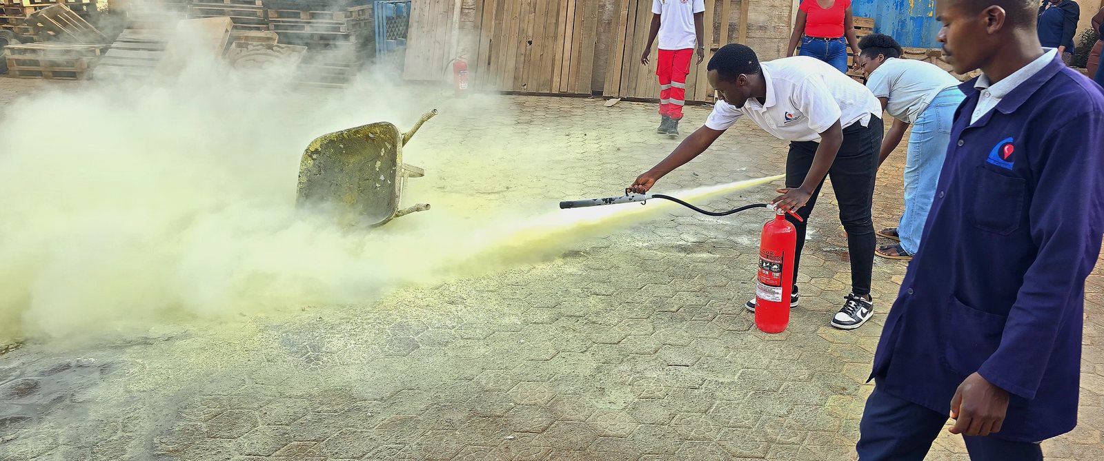Biomedics Products staff member practising with a fire extinguisher during fire safety training